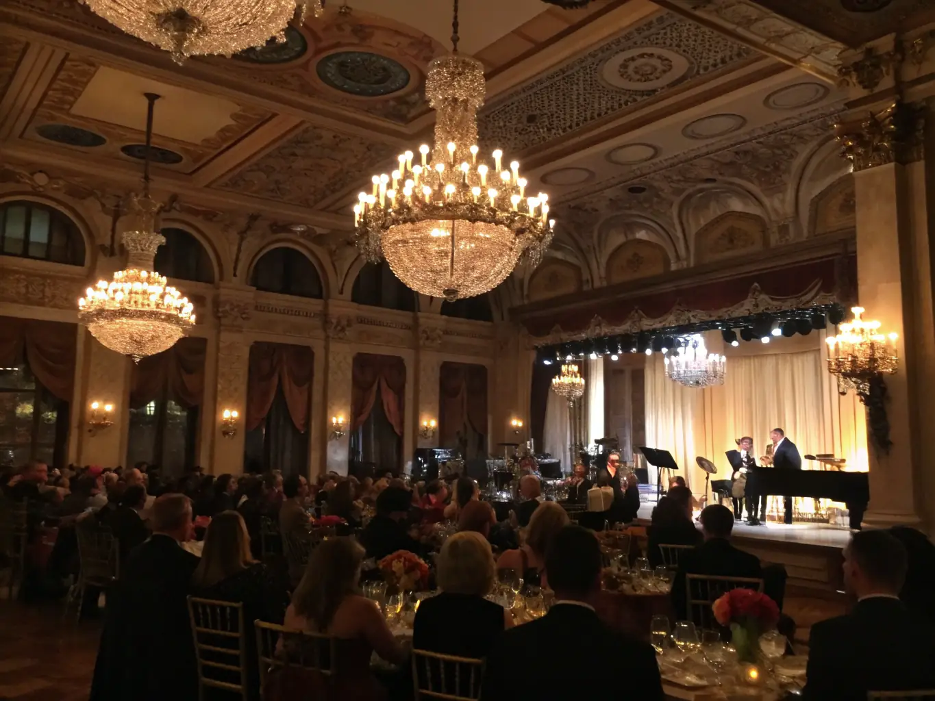 A vibrant photo of a classical music concert held in the grand hall of Château de Blosset, with an attentive audience and ornate XVIIIe-century decor, illustrating a cultural event organized by the association.